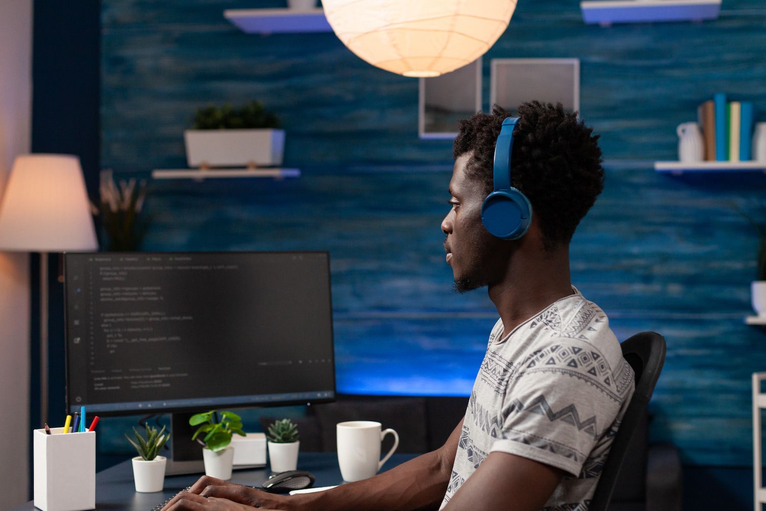 man discussing something with a colleague in front of a laptop