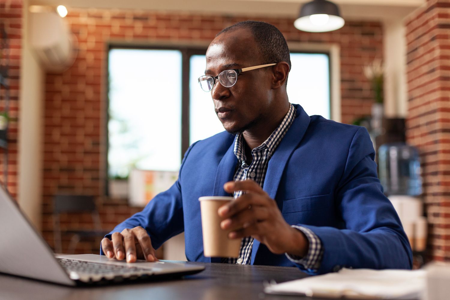 man discussing something with a colleague in front of a laptop